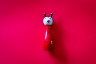 在充满活力的红色背景下，明亮的木制瓢虫玩具非常适合有趣的主题