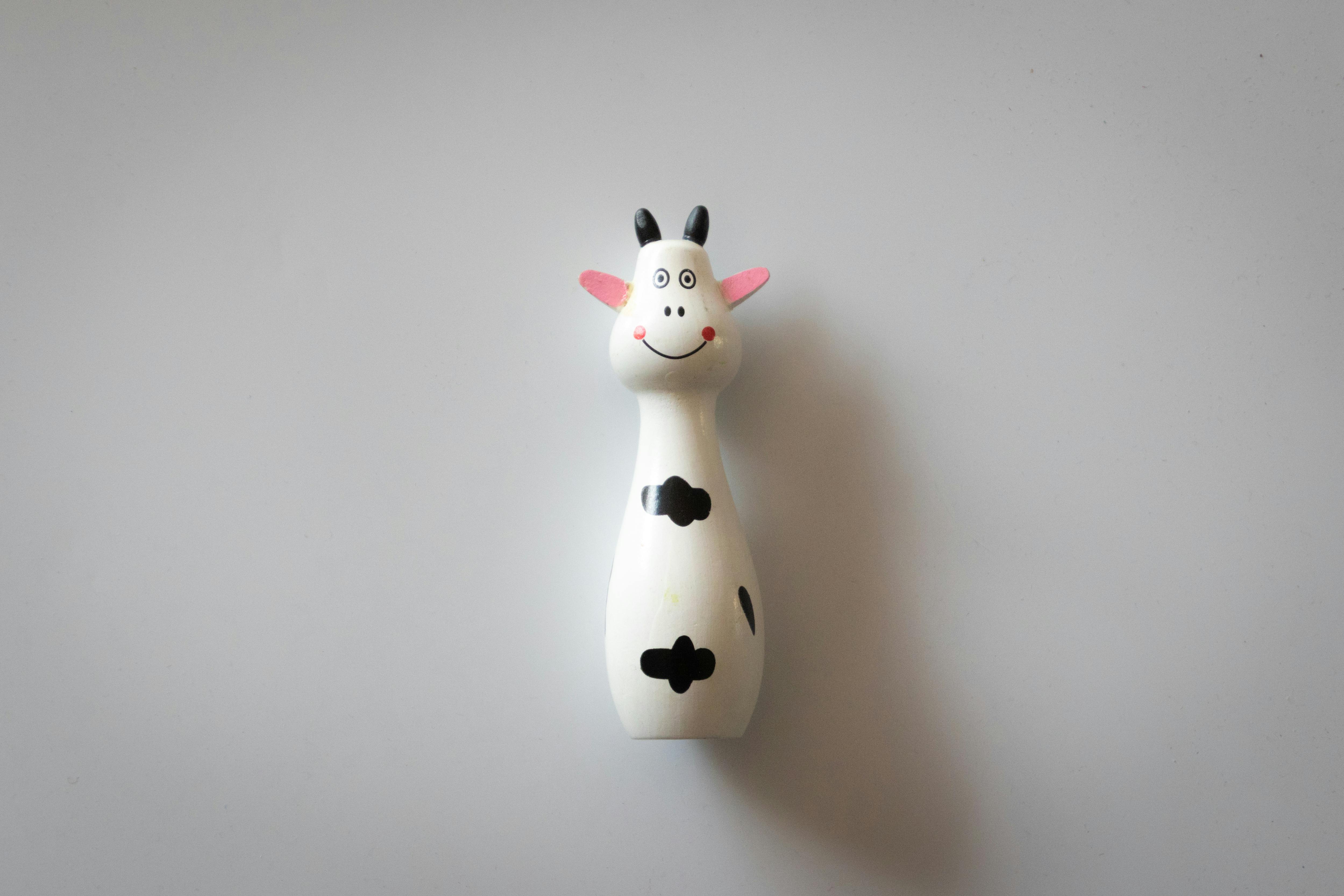 white and black cow figurine