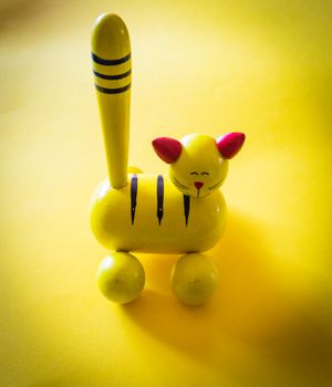 Yellow wooden cat toy on a yellow background, photo by Magda Ehlers on Pexels
