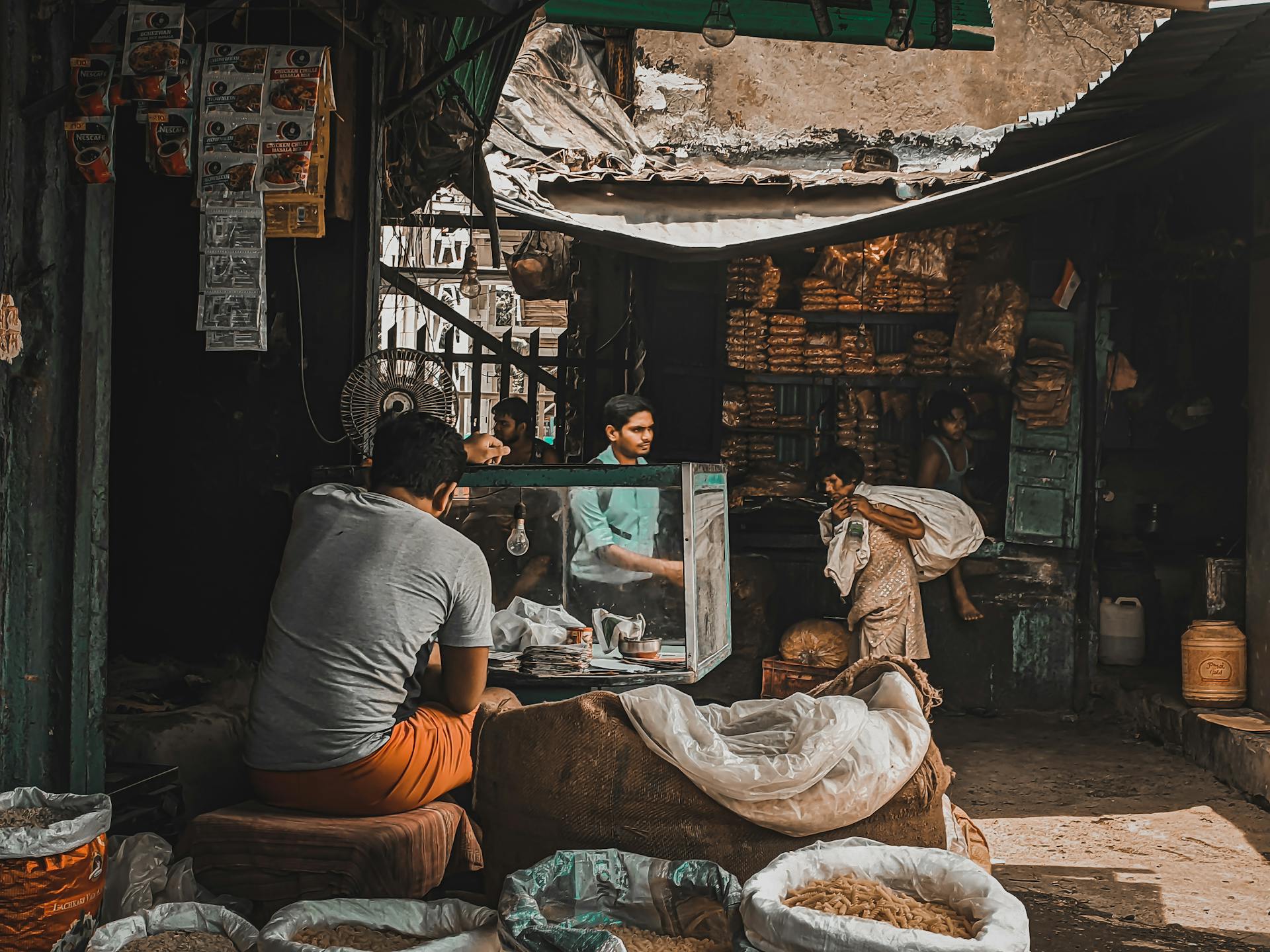 A vibrant street market with multiple vendors and shoppers engaging in commerce.