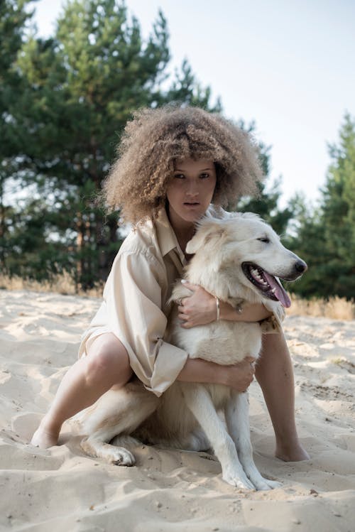 Woman Hugging a Dog on the Beach