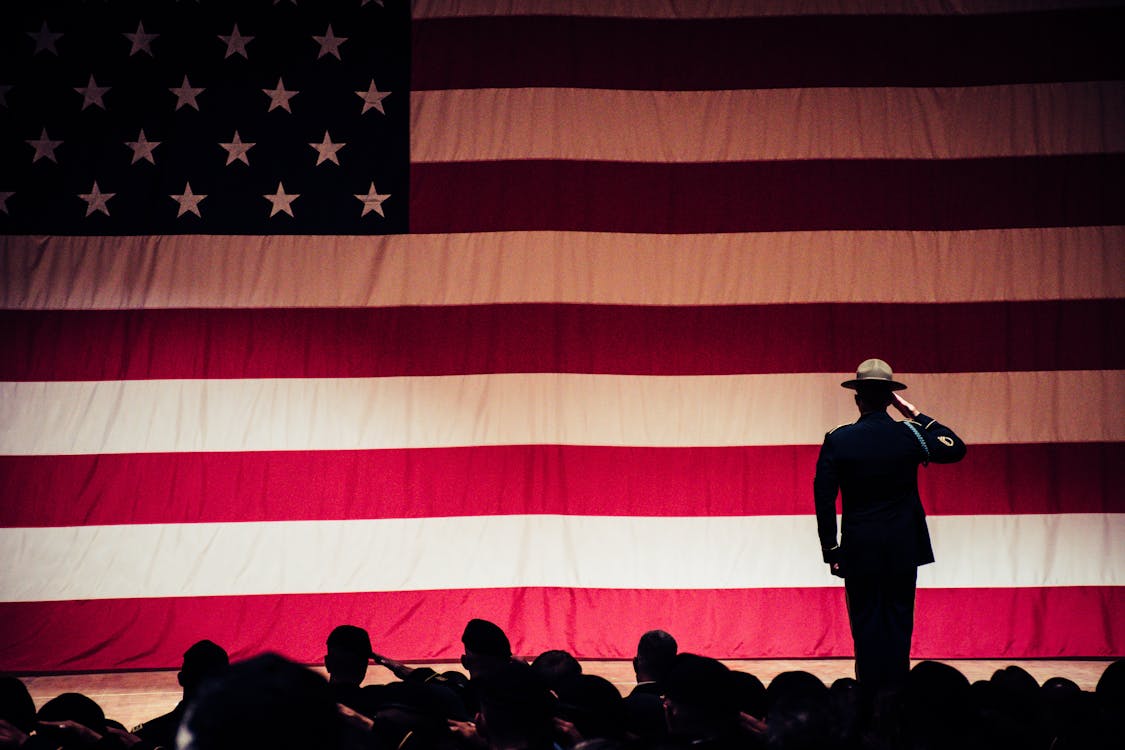 Free Man Standing On Stage Facing An American Flag Stock Photo