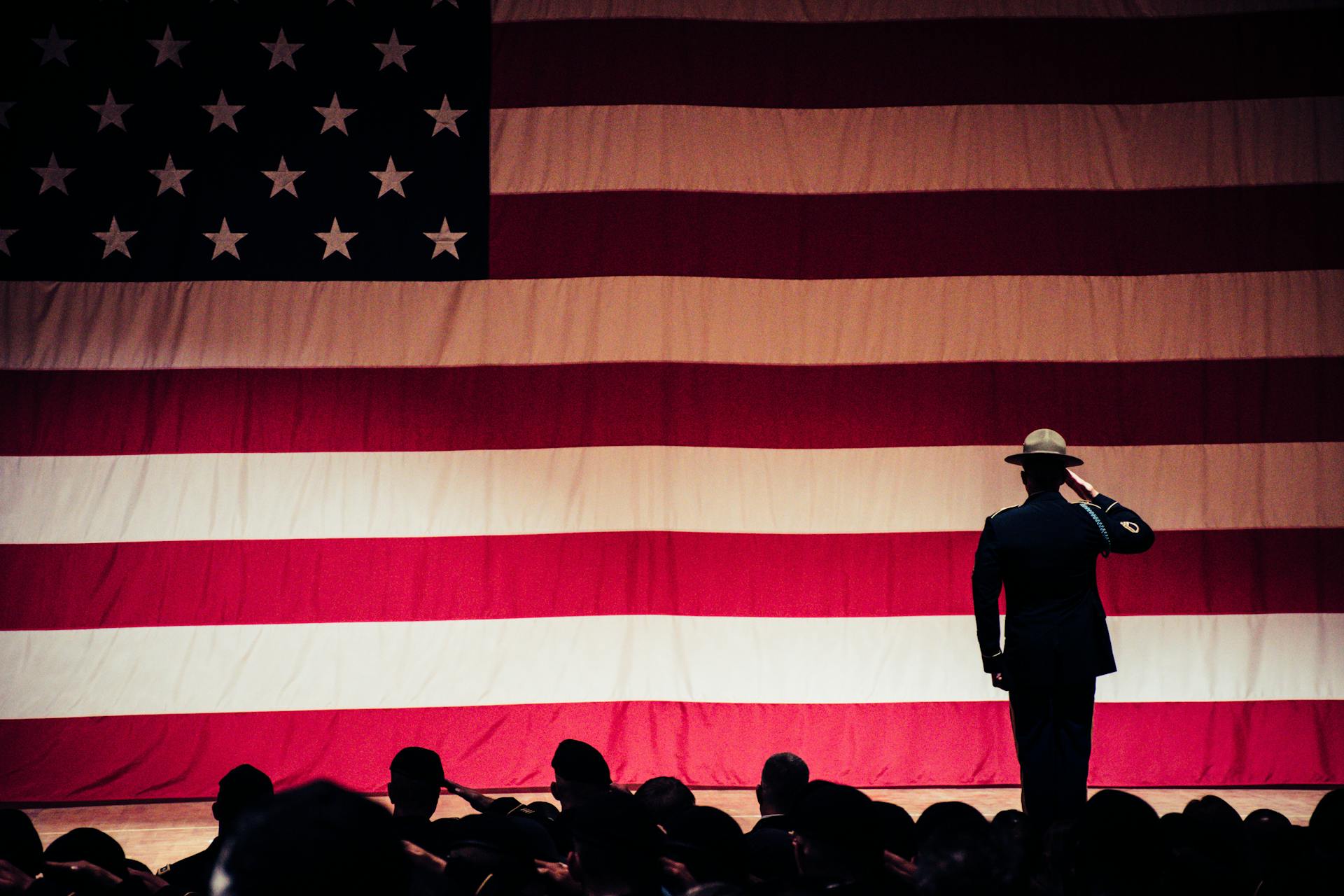 Man staat op het podium tegenover een Amerikaanse vlag