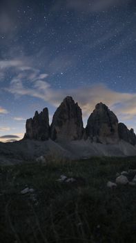 Captivating night sky view over Tre Cime di Lavaredo's rock formations.