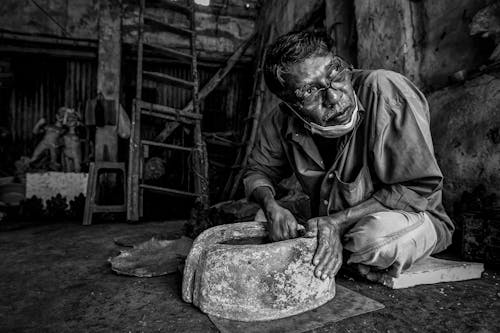 Grayscale Photo of a Man Making Pots