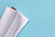 浅蓝色背景上，一本打开的书呈现着俄语文本，构图极简