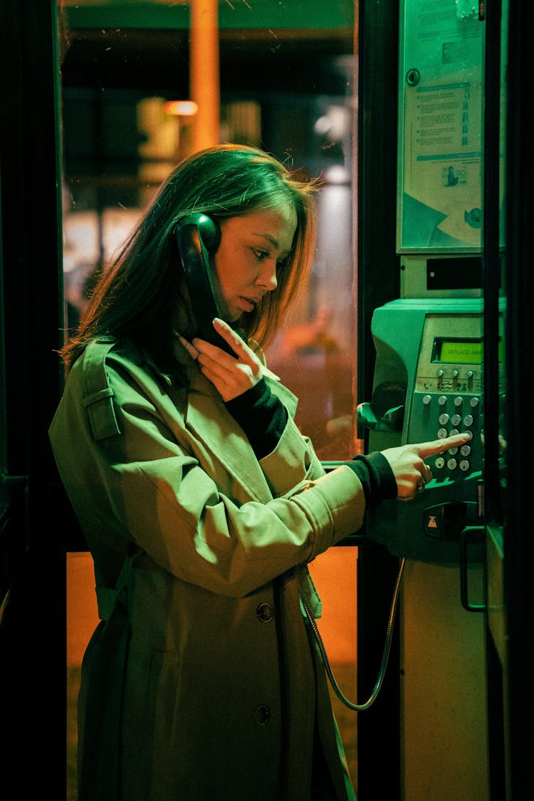 Woman Using A Public Telephone