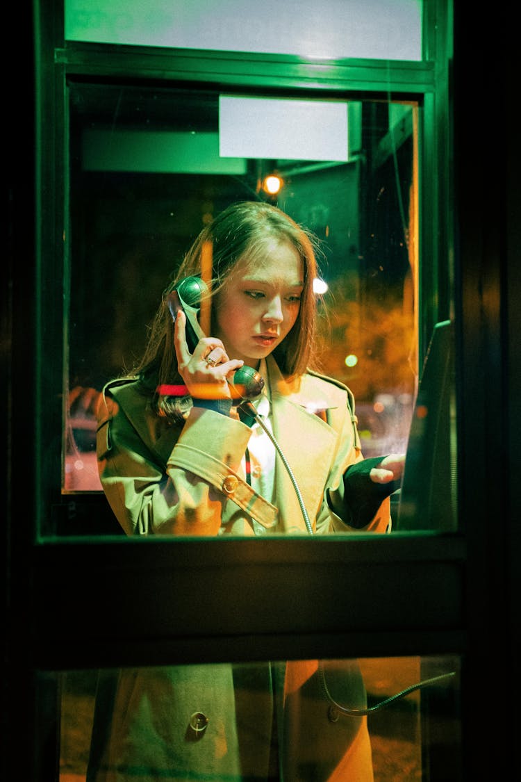 Woman Using A Telephone Booth