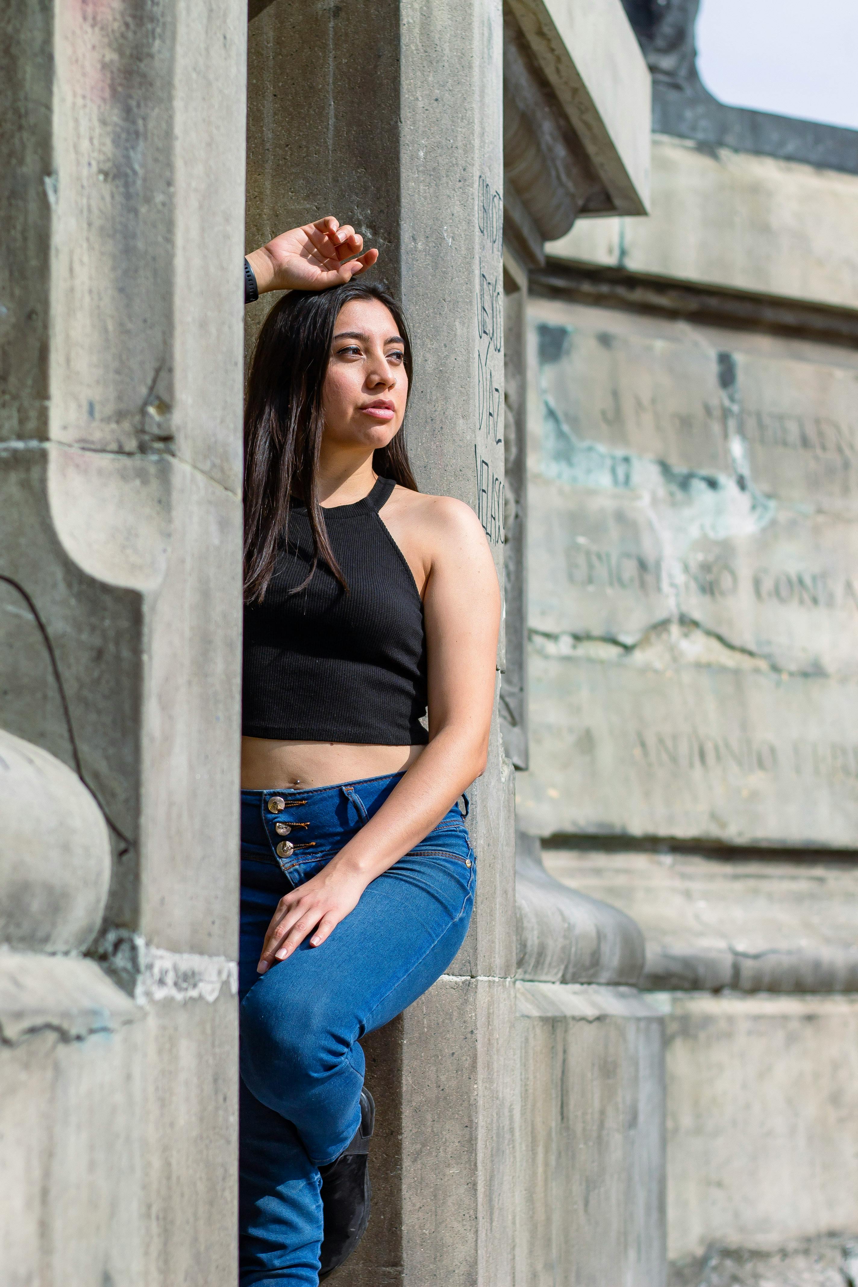 Woman in Black Crop Top and Denim Jeans Leaning on the Wall while Looking  Afar · Free Stock Photo