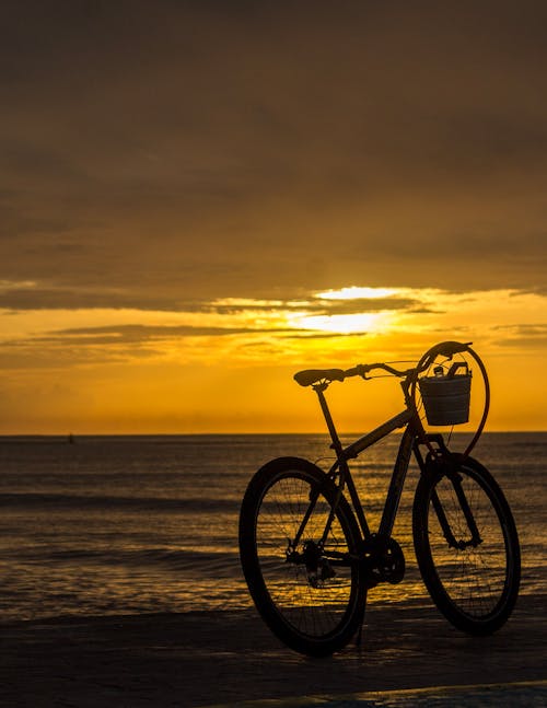 Foto profissional grátis de arenoso, bicicleta, céu dourado