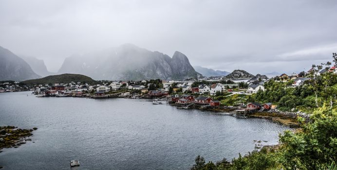 薄雾缭绕的港口景色中，迷人的村庄坐落在宁静的海岸线上