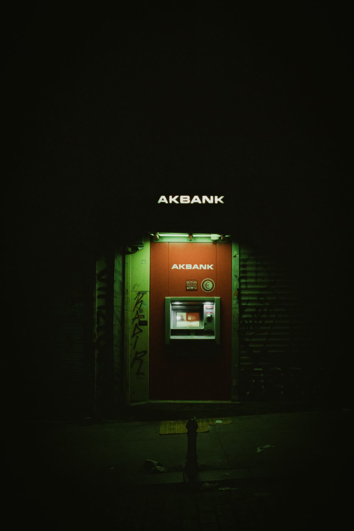 A wall-mounted cash machine on the side of a city street.