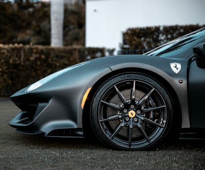 Detailed close-up of a luxury supercar wheel and front on grass.