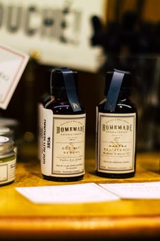 Close-up of vintage style apothecary bottles labeled 'Homemade' on a wooden shelf.