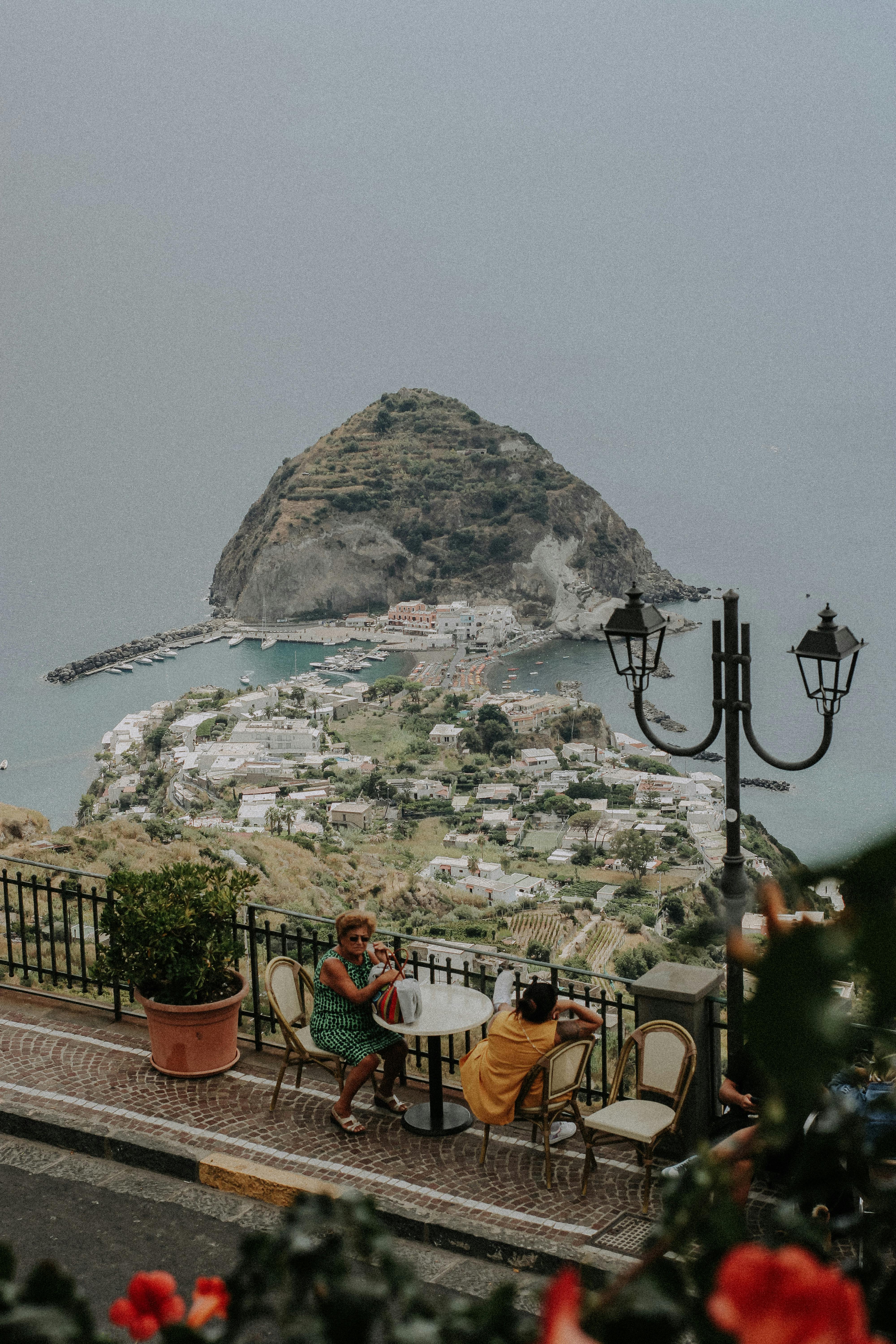 A stunning view of Sant'Angelo Island from a terrace with two women enjoying the scenery.