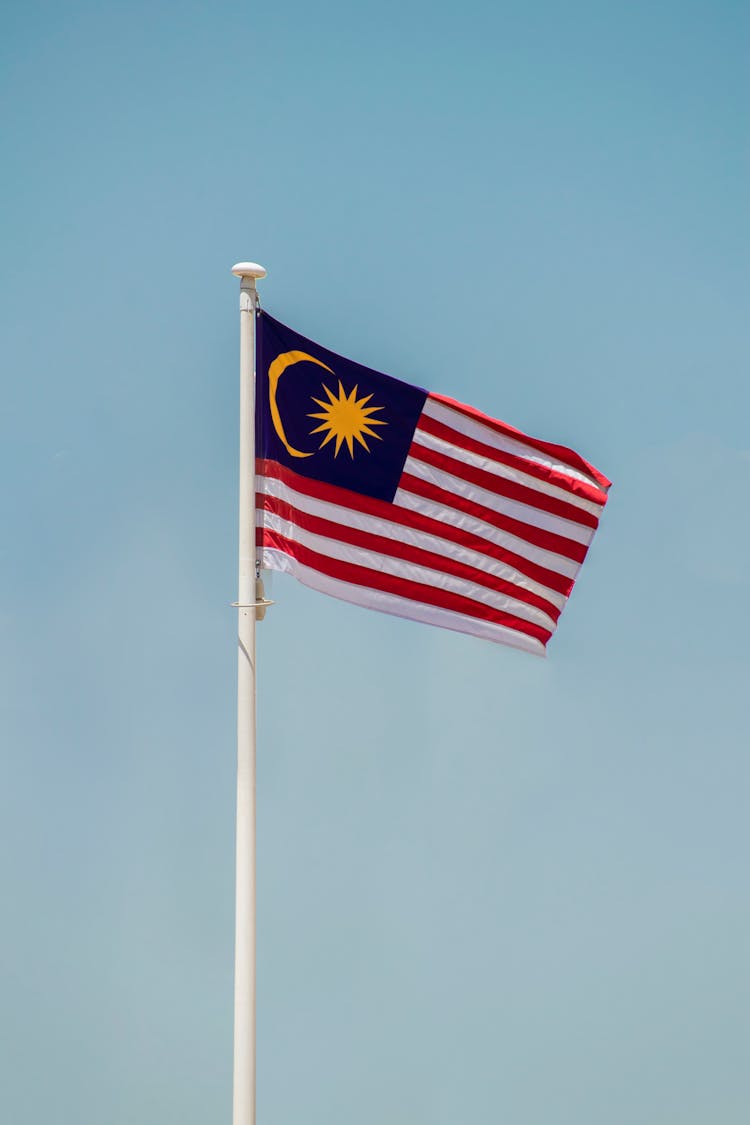 The Flag Of Malaysia Under The Blue Sky 