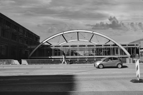 Free Grayscale Photo of a Car Near a Building Stock Photo