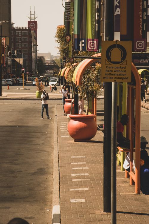Free Colorful street scene in Johannesburg, South Africa featuring red clay pots and urban architecture. Stock Photo