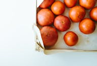 纸板箱里整齐地排列着新鲜的有机西红柿，呈现出鲜艳的红色