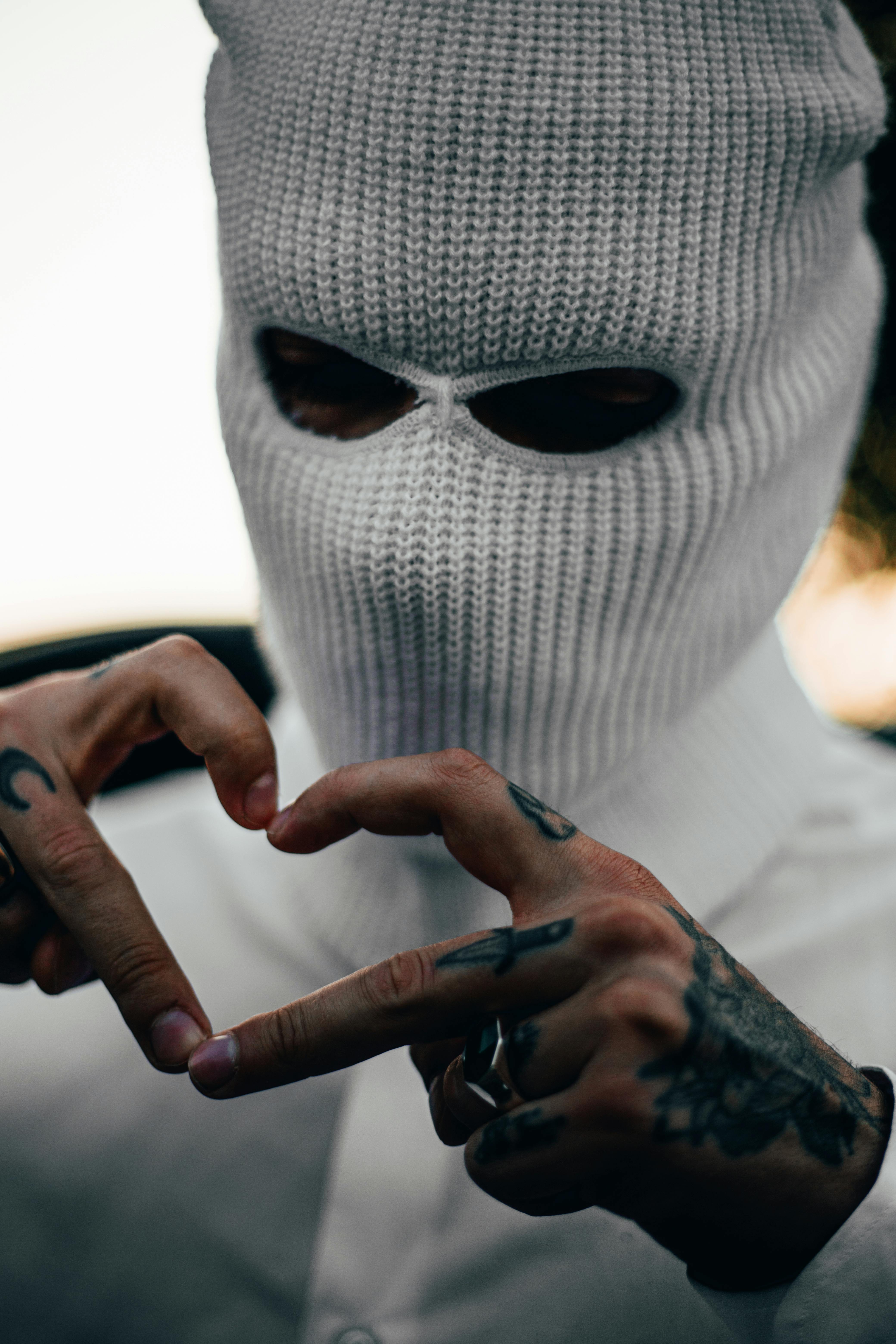 A Tattooed Man in a Ski Mask Making a Heart Sign · Free Stock Photo