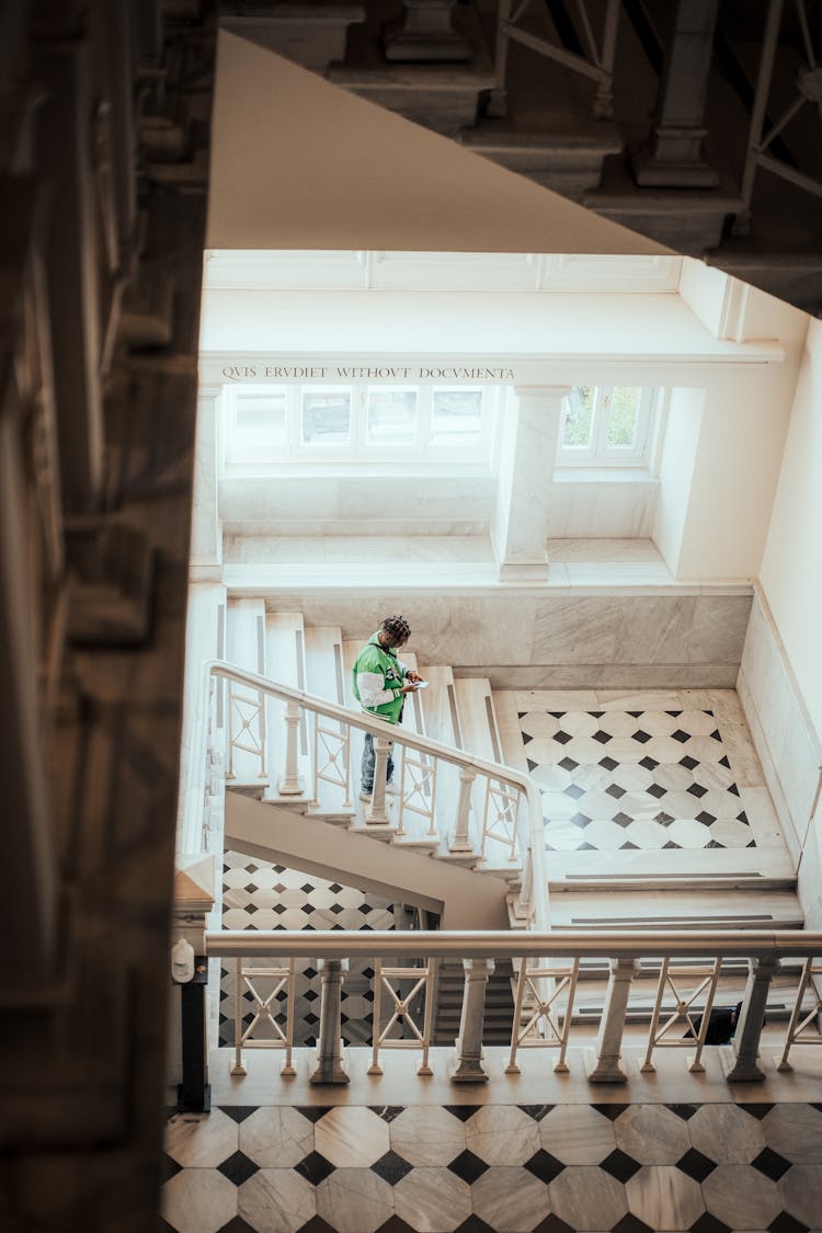 Man In Green Jacket Standing On The Stairs