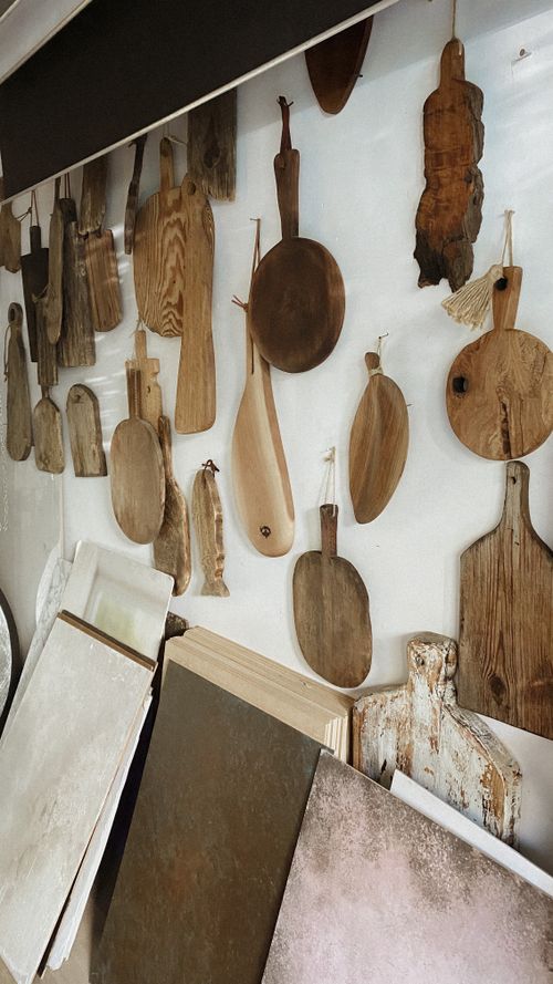 Free Wooden chopping boards artistically displayed on a white wall indoors, creating a rustic aesthetic. Stock Photo