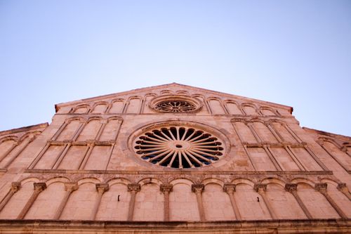 Free Elegant low angle shot of a gothic cathedral facade with intricate rose window design. Stock Photo