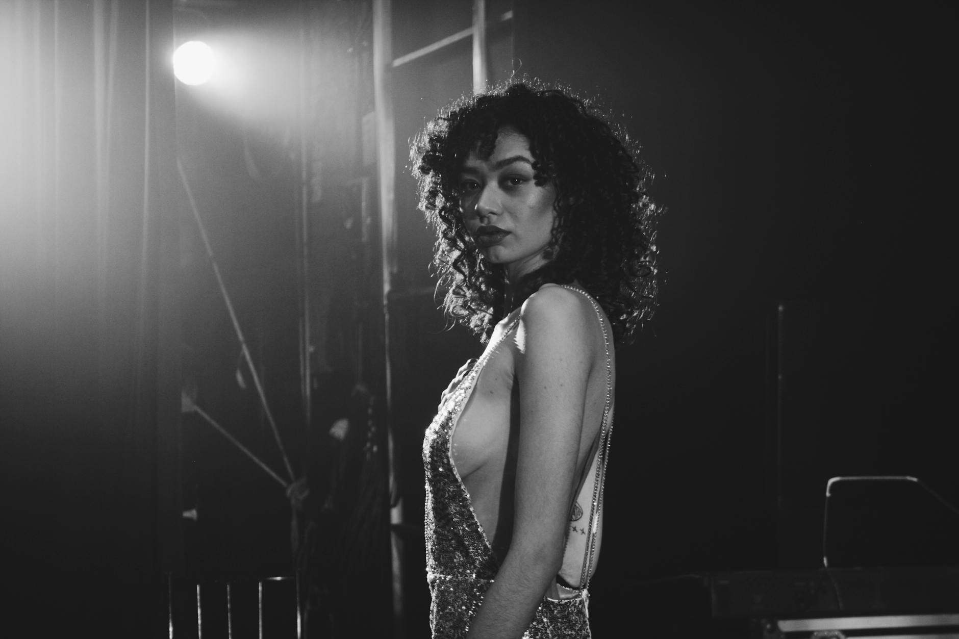 Sahne ışıkları altında özgüvenle duran, aslan burcunun görkemli ve dikkat çekici doğasını temsil eden karizmatik bir figür.