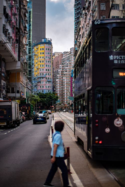 Free Dynamic Hong Kong street view with colorful buildings and a moving tram, capturing urban life. Stock Photo