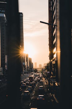 Captivating sunset scene in a bustling city with traffic and tall buildings. Perfect for urban lifestyle themes.