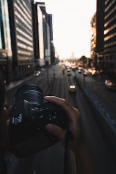 A photographer captures the bustling energy of a city street at sunset. Urban life photography.