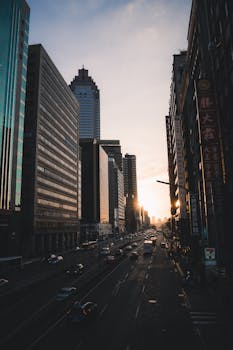 Elevated view of city skyscrapers and traffic during sunset, showcasing urban life.
