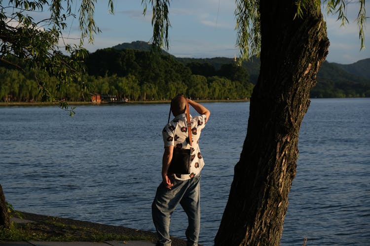 Backview Of Man Standing On A Lakeside 