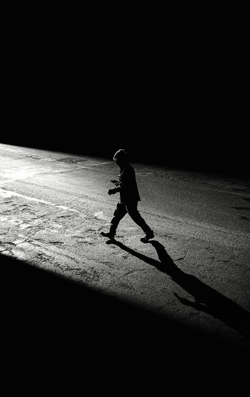 Silhouette of Person Walking on a Road 
