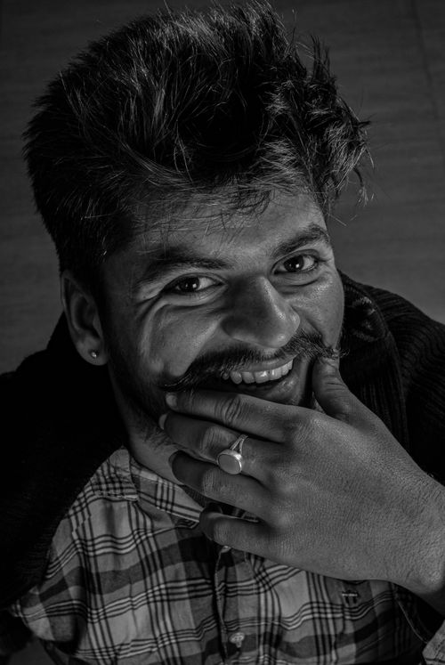 Free Black and white portrait of a smiling South Asian man with playful expression in Chandigarh, India. Stock Photo