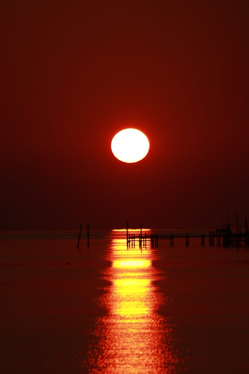The Sun on an Orange Sky Over a Body of Water