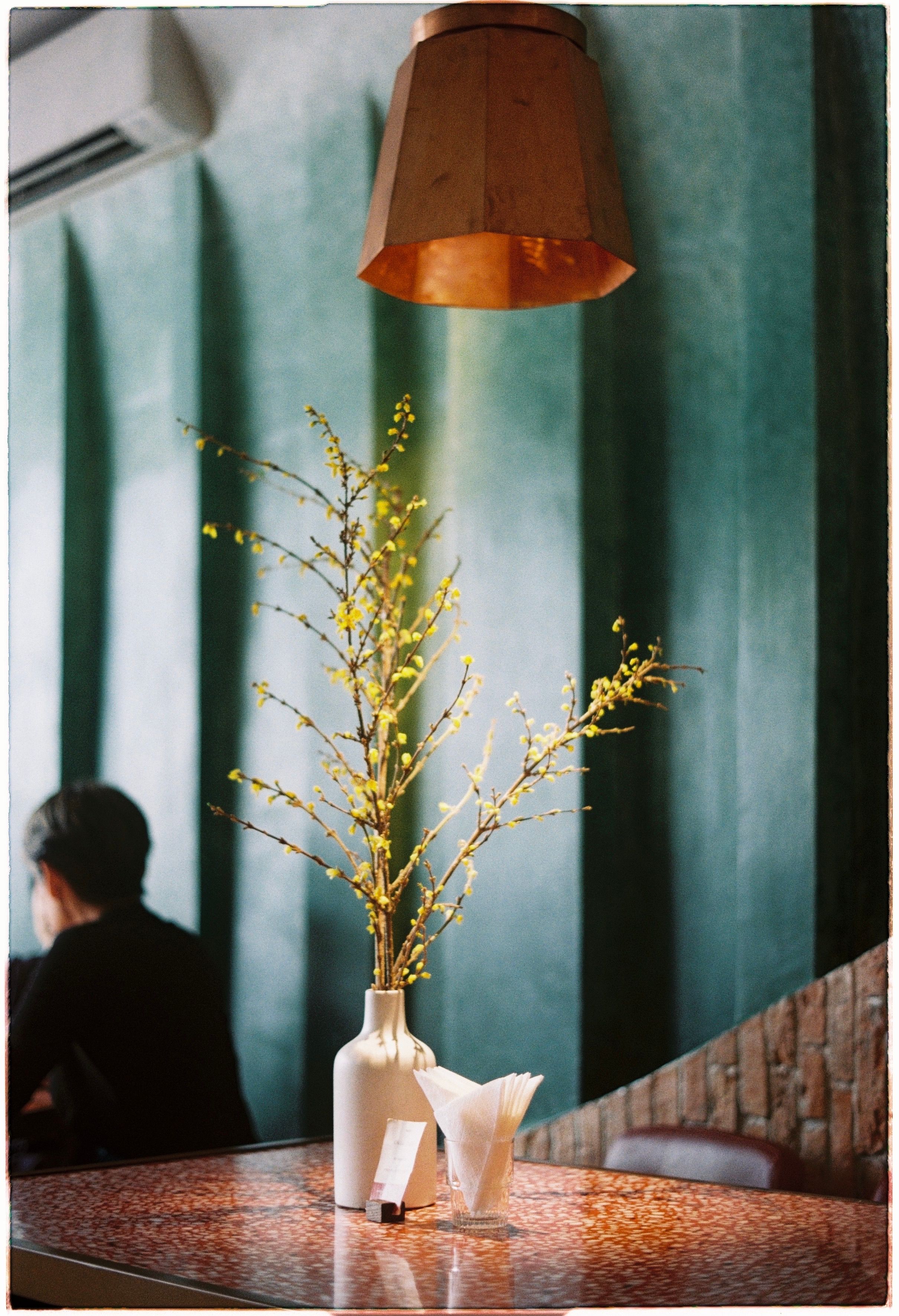 Chic interior with a white vase on a marble table, adorned by pendant lamp lighting.