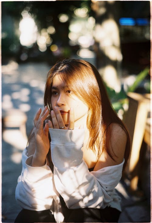 Woman in White Sleeveless Shirt with Hand on Her Face