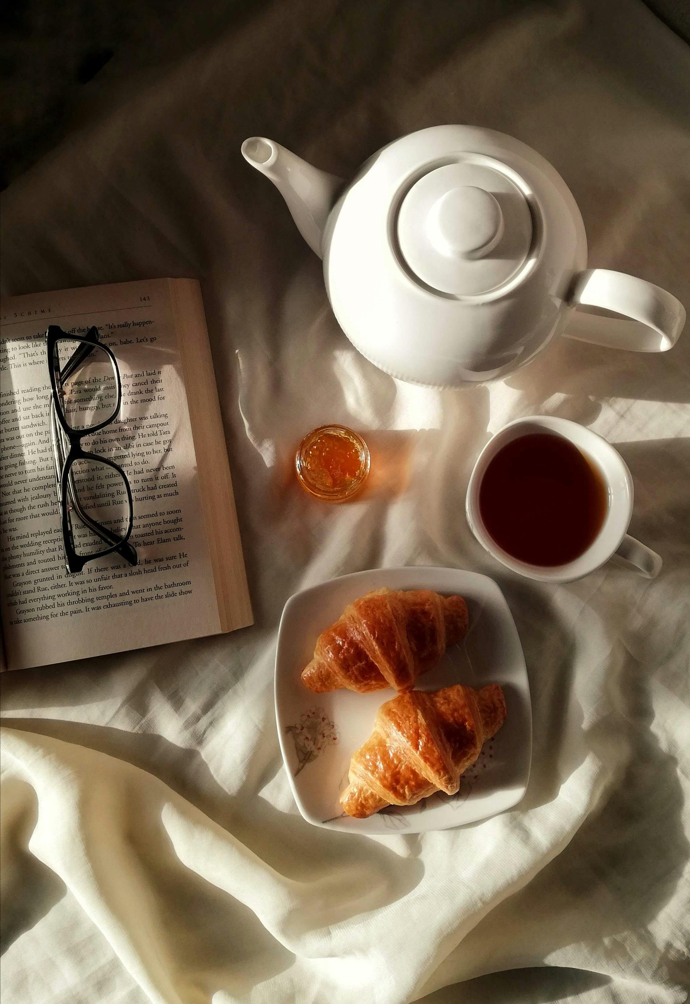 Enjoy a peaceful morning with tea, croissants, and a good book on a bright, sunny day.