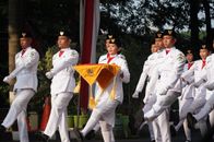 Indonesian soldiers in uniform marching in a ceremonial parade outdoors.