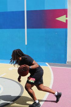 Action shot of a basketball player on a colorful outdoor court in Paris, France.