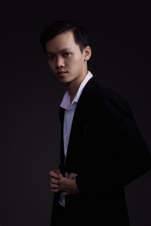 Free Portrait of a young man in formal attire against a dark background. Stock Photo
