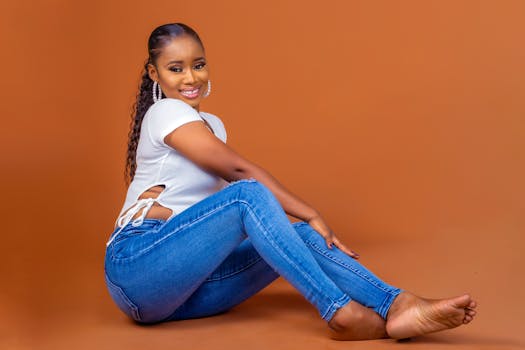 Portrait of a stylish woman sitting on a warm-toned background, showcasing elegance and fashion.