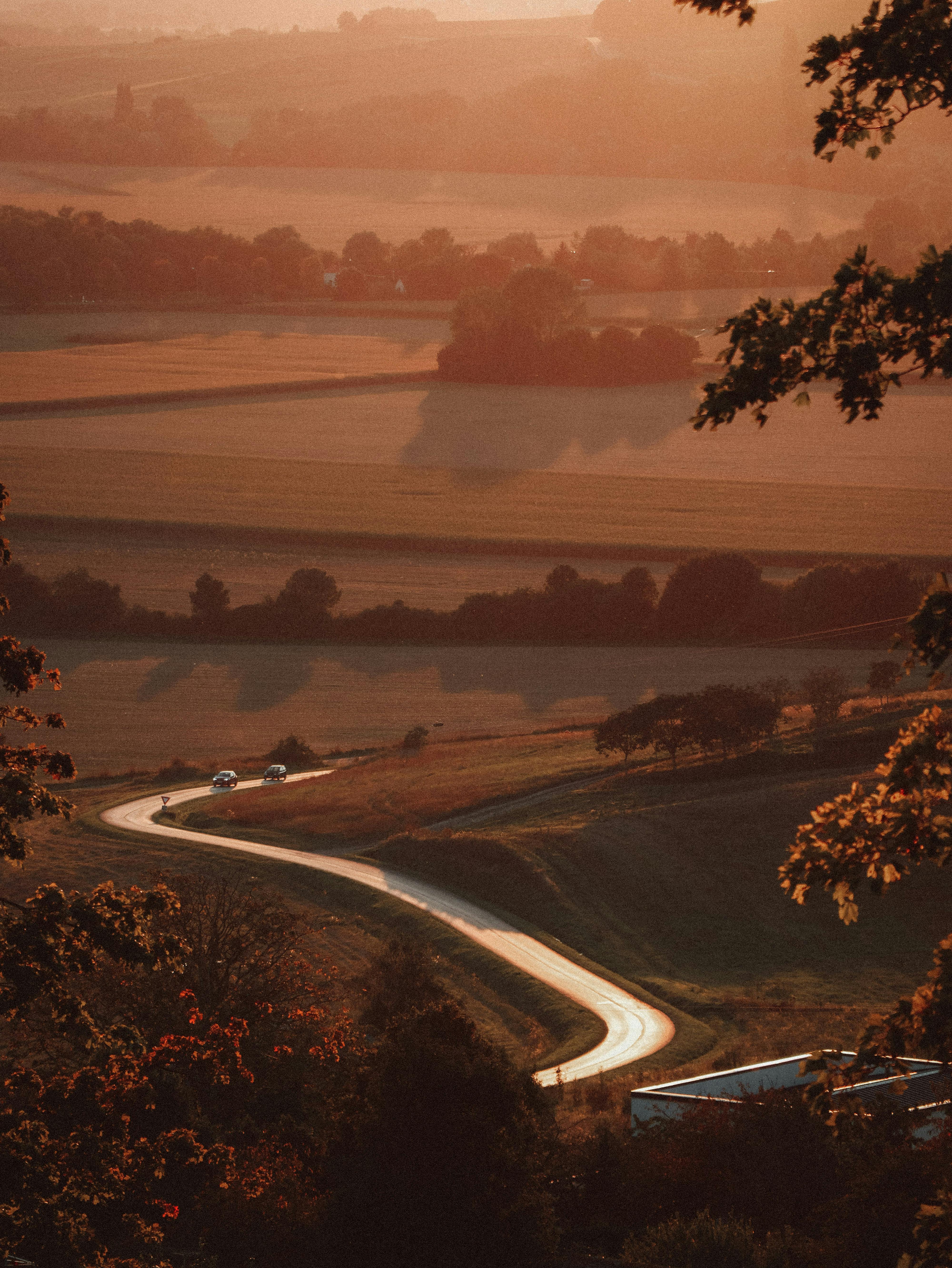 A picturesque aerial view of winding roads and fields at sunset in Châtillon-sur-Marne, Grand Est, France.