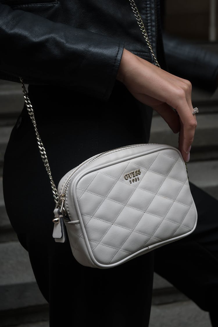 A Woman Carrying A White Guess Bag