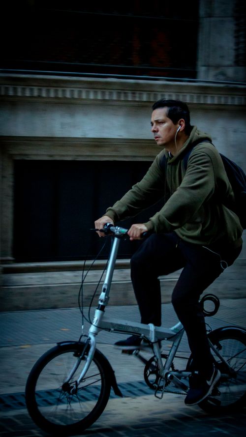 Free A man rides a bicycle while listening to music in Buenos Aires, Argentina. Stock Photo