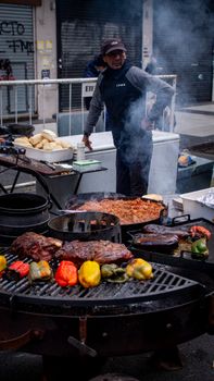 A vibrant street food scene with grilling meats and peppers in Buenos Aires, Argentina.