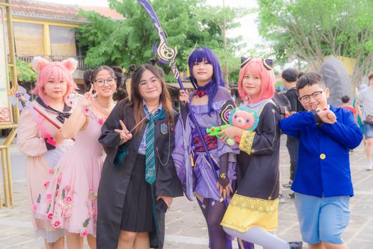 A lively group of cosplayers in colorful costumes posing outdoors at an event.