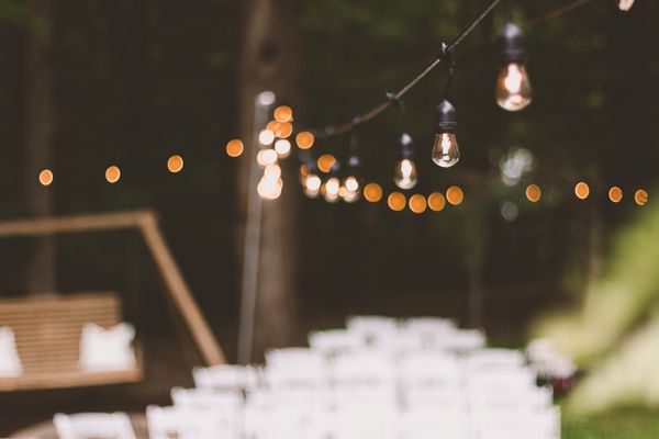 Warm string lights illuminating an outdoor garden setting at dusk