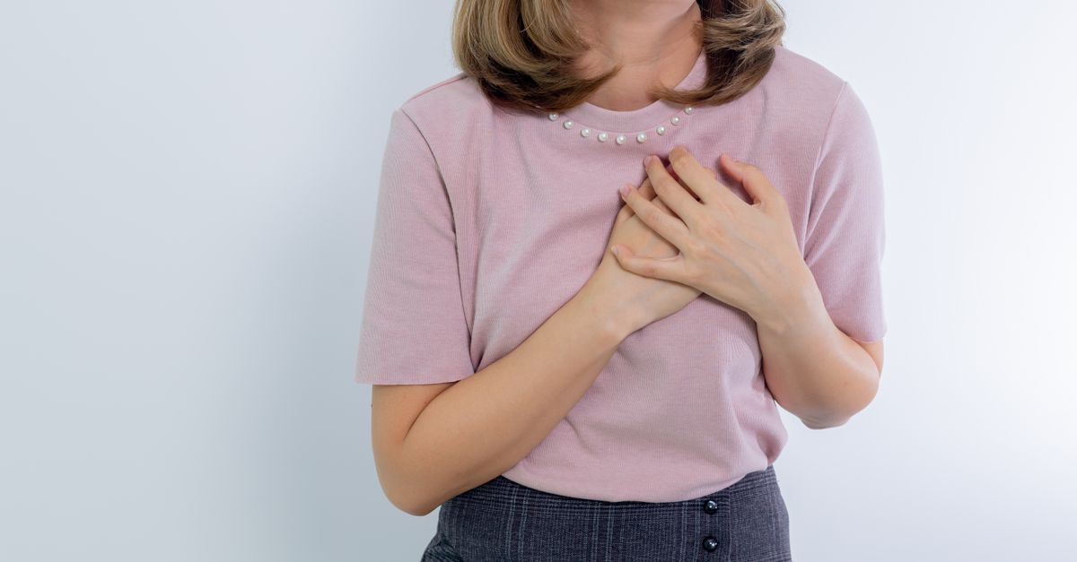 Rüyada Aşkta Kalp Acısı Çekmek - Rüya Tabiri ve Anlamı - A woman holds her chest conveying emotion or heartache.